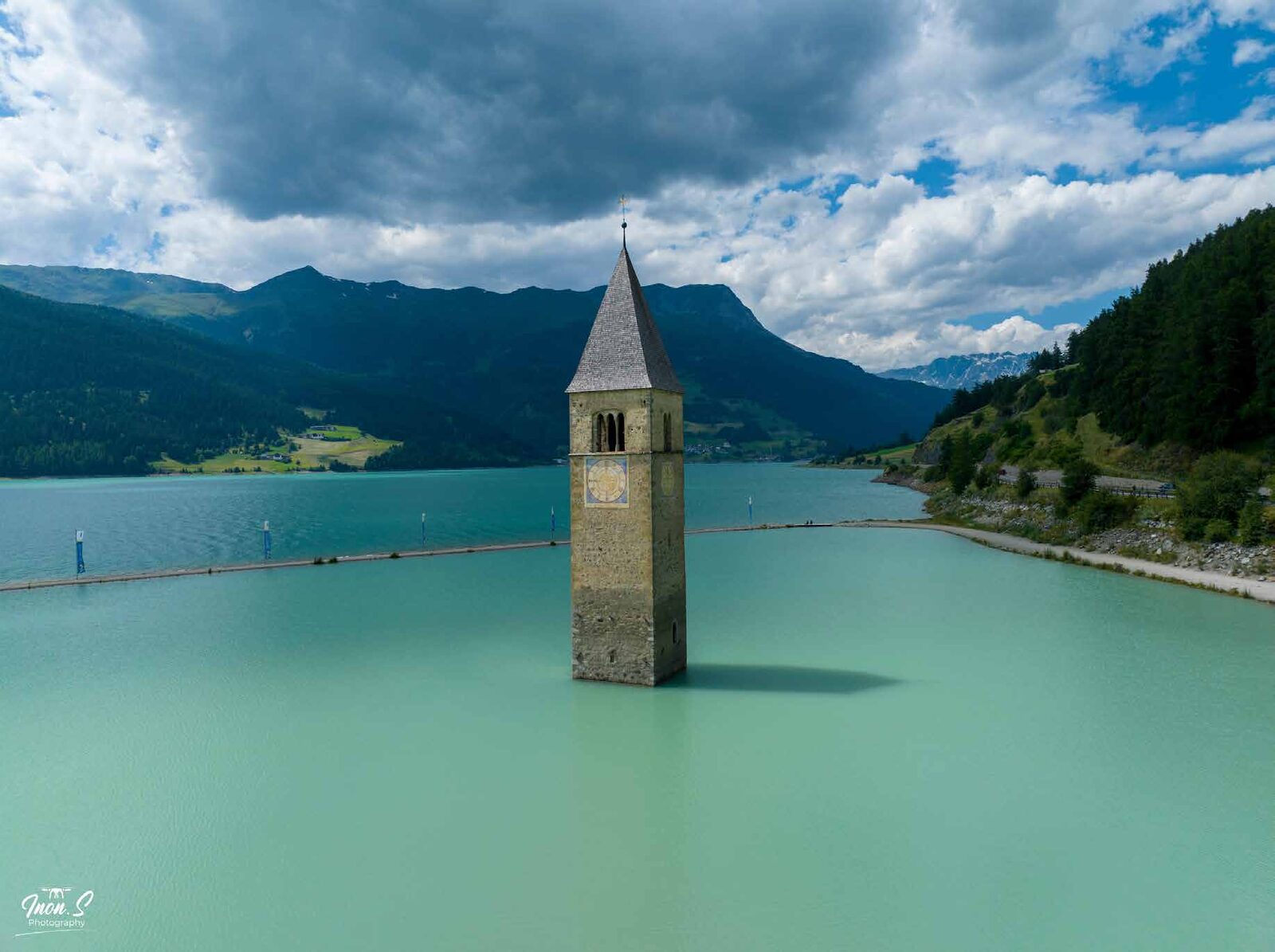 Church tower rising from a turquoise lake